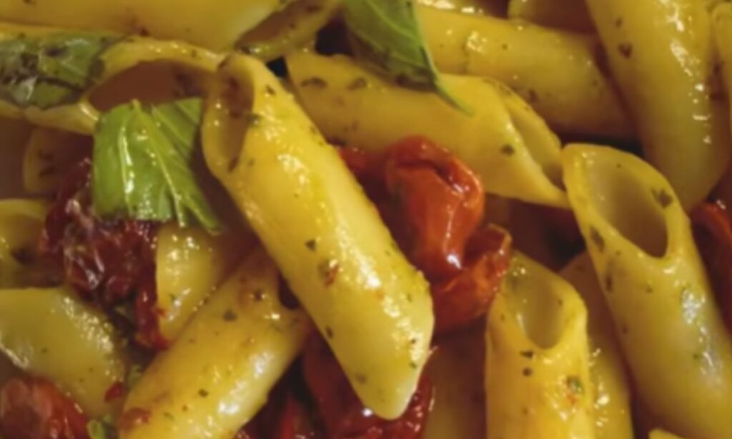 Penne candela condite con pesto genovese, pomodorini confit e basilico.