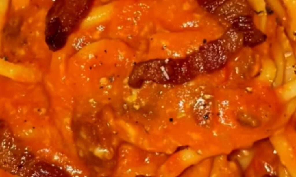Tonnarelli all’amatriciana con pomodoro, guanciale e pecorino romano, serviti in padella.