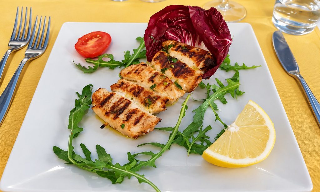 Involtini di pesce spada con segni della griglia, serviti su un piatto quadrato con rucola e limone.