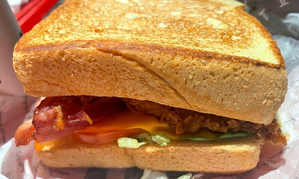 Colonel’s Red Sandwich con pane tostato, bacon croccante, formaggio fuso e filetto di pollo impanato da KFC a Rende